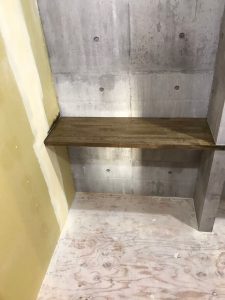 壁面のコンクリートデザインのクロスと作り付けの棚
